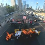 WATCH: Activists block main Tel Aviv highway, set Shabbat table on fire in protest for a Gaza deal